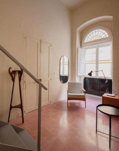 a living room with a staircase and a chair at Charming Studio in Historic Centre in Birgu