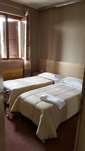 two beds in a room with two windows at B&B Bed& Fly - Mamma Mia in Azzano San Paolo