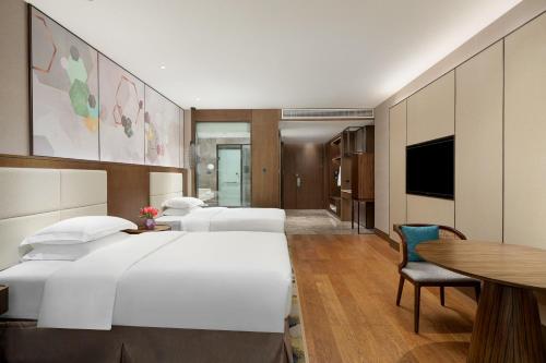 a hotel room with two beds and a table at Crowne Plaza Beihai Silver Beach by IHG in Beihai