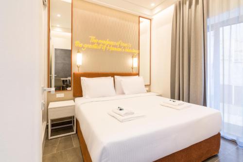 a bedroom with a large white bed and a mirror at Socrates Fully Equipped Apartments with Unique Design in Athens