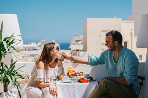 Un hombre alimentando a una mujer con un plato de comida. en Giorgio Boutique Hotel, en Sliema