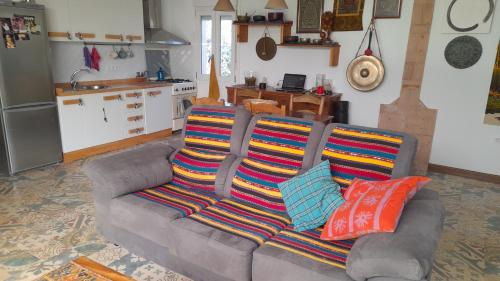eine Couch mit bunten Kissen darauf in einem Wohnzimmer in der Unterkunft Casa Rustica in El Puerto de Santa María