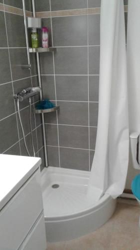 La salle de bains est pourvue d'une douche avec rideau de douche blanc. dans l'établissement Studio Saint Jean De Monts, à Saint-Jean-de-Monts