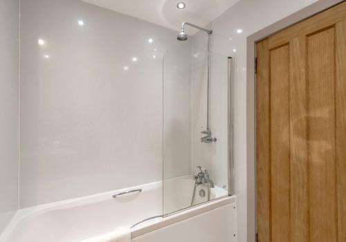 Un baño blanco con ducha y bañera. en Causewayside Apartment - The Edinburgh Address, en Edimburgo