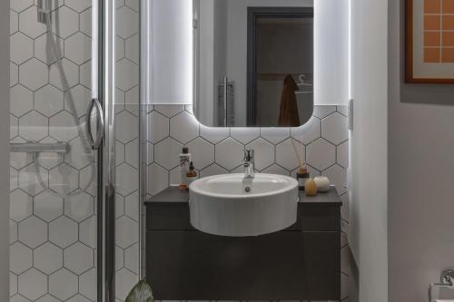 a bathroom with a white sink and a mirror at ARK Wembley in London