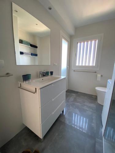 a white bathroom with a sink and a toilet at Apartamento El Palmeral Aguadulce in Aguadulce
