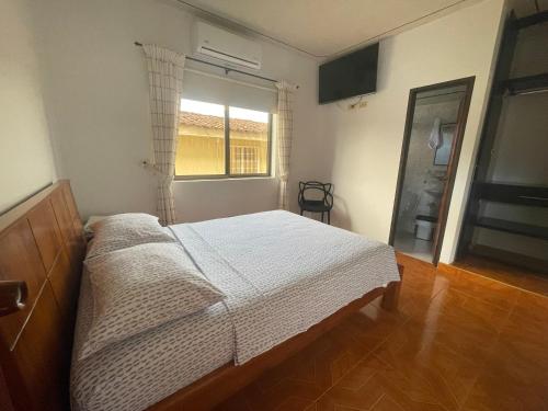 a bedroom with a large bed and a window at Hospedaje Castillo Real in Roldanillo