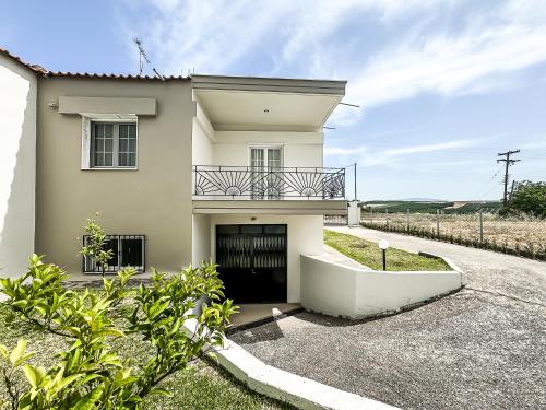 a white house with a balcony on top of it at The Serenity Villa #PROPERTLY in Nea Kallikrateia