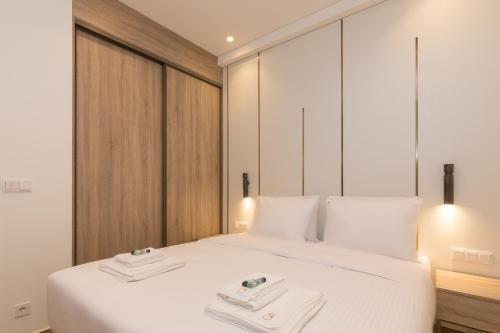 a bedroom with a white bed with two towels on it at Socrates Fully Equipped Apartments with Unique Design in Athens