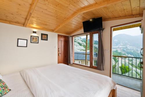 a bedroom with a bed and a large window at Jomotel Dayaar - An Apple Orchard Villa in Theog