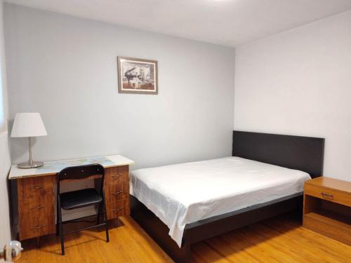 トロントにあるspacious and bright houseのベッドと机と椅子のある寝室