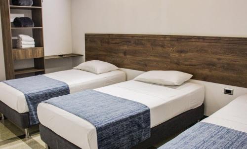 two beds in a room with two at Hotel Boutique Estadio in Medellín