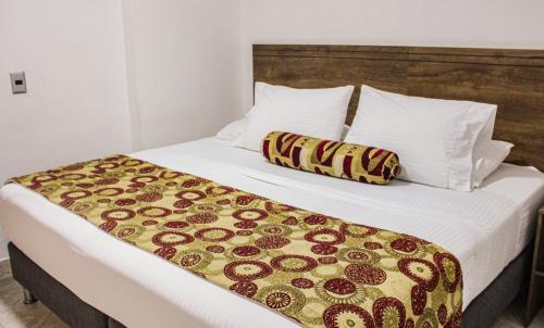 a bed in a hotel room with a blanket on it at Hotel Boutique Estadio in Medellín