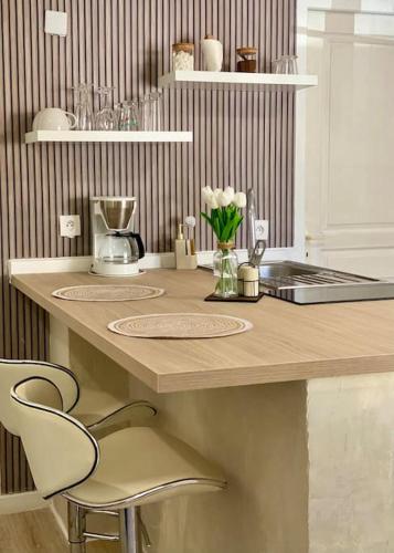 une cuisine avec un comptoir, un évier et une chaise dans l'établissement Appartement neuf, à Avignon