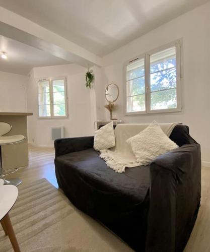 un salon avec un canapé noir dans une pièce dans l'établissement Appartement neuf, à Avignon