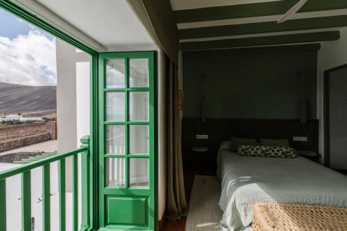 a bedroom with a bed and a balcony at César Lanzarote Luxury Boutique Hotel - Adults Only in La Asomada