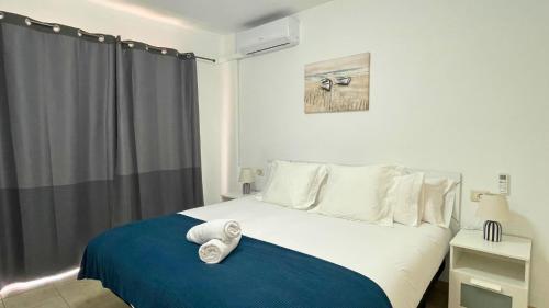 Un dormitorio con una cama con una manta azul. en MarketHome Jardines del Mar Pool View, en Puerto de Santiago