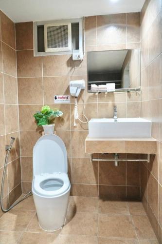 a bathroom with a toilet and a sink at Bkk39 Airport hotel in Ban Khlong Prawet