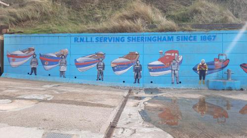 a blue wall with people painted on it at Flower Garden Studio in Sheringham-Cycle friendly in Sheringham