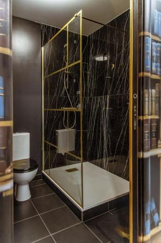 une salle de bain avec une douche en verre et des toilettes dans l'établissement Le Gatsby à 20 mn de Disney, à La Ferté-sous-Jouarre
