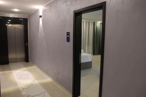 a hallway with a mirror and a room with a bed at OLD BaTuMi in Batumi