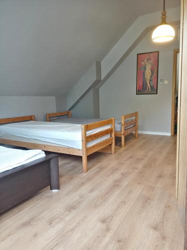 two beds in a room with wooden floors at Apasjonata in Świdnica