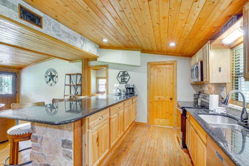 a large kitchen with wooden cabinets and a wooden ceiling at Deck and Fire Pit Unique Pottsboro Haven in Pottsboro