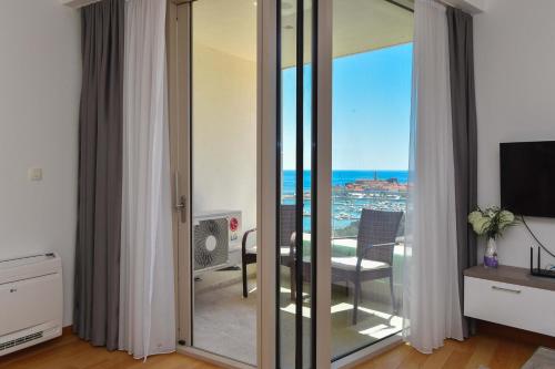 a room with sliding glass doors with a view of the ocean at Apartman Drobnjak Center-sea View in Budva