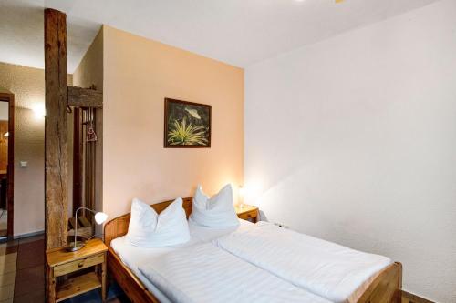 a hotel room with a bed with white sheets at Krüseliner Mühle - Ferienwohnungen in Krüselin