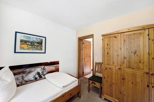 a bedroom with a bed and a wooden cabinet at Krüseliner Mühle - Ferienwohnungen in Krüselin
