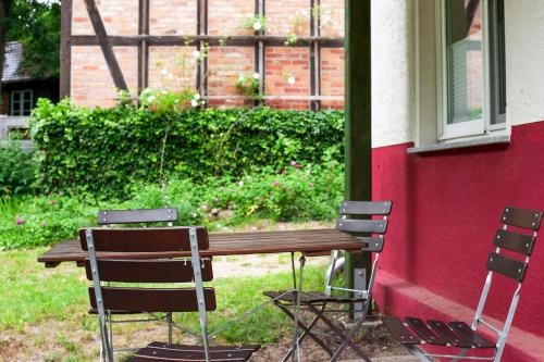 a wooden table and chairs next to a building at Krüseliner Mühle - Ferienwohnungen in Krüselin