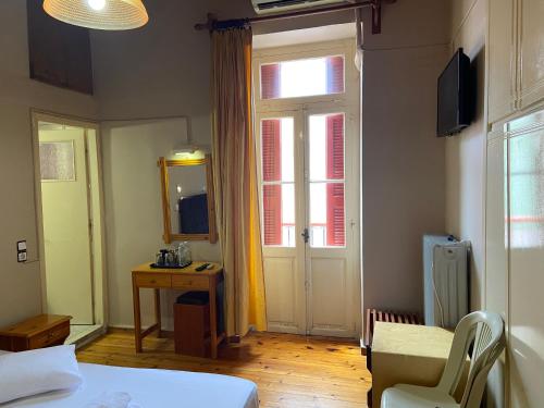 a bedroom with a bed and a window and a door at Hotel EPIDAVROS in Nafplio
