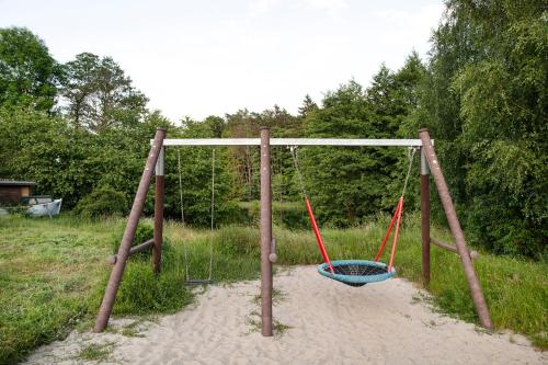 a swing in the sand in a field at Krüseliner Mühle - Ferienwohnungen in Krüselin