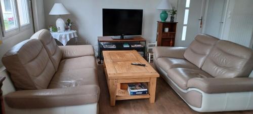 un salon avec deux canapés et une télévision dans l'établissement maison centre ville, à Bayeux