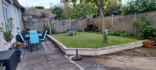 une cour avec une table, des chaises et un arbre dans l'établissement maison centre ville, à Bayeux
