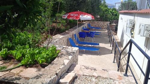 a patio with a table and chairs and an umbrella at Sky Apartments in Sarandë