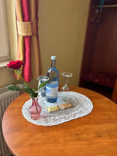 a bottle of alcohol and a flower on a table at Hotel Ostseeblick - direkt hinter den Dünen in Ostseebad Karlshagen