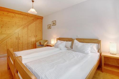 a bedroom with a large bed with white sheets at Ferienhof Schütz in Eschlkam