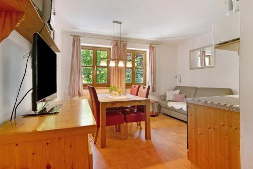 a kitchen and living room with a table and a television at Ferienhof Schütz in Eschlkam