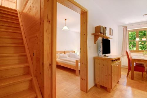 a bedroom with a bed and a desk with a television at Ferienhof Schütz in Eschlkam