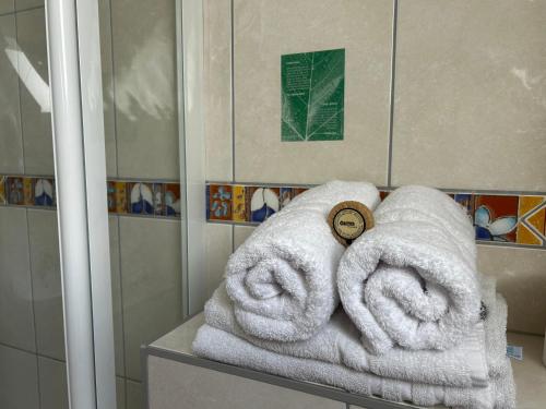 a pile of towels sitting on a counter in a shower at Hotel Ostseeblick - direkt hinter den Dünen in Ostseebad Karlshagen