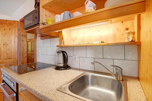 a kitchen with a stainless steel sink and wooden cabinets at Ferienhof Schütz in Eschlkam
