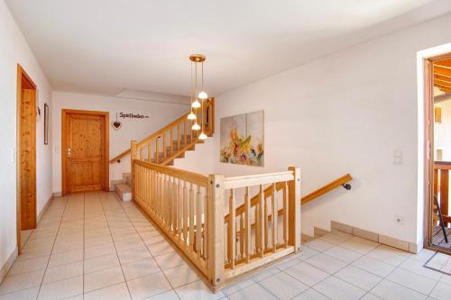 a staircase in a home with a wooden railing at Ferienhof Schütz in Eschlkam