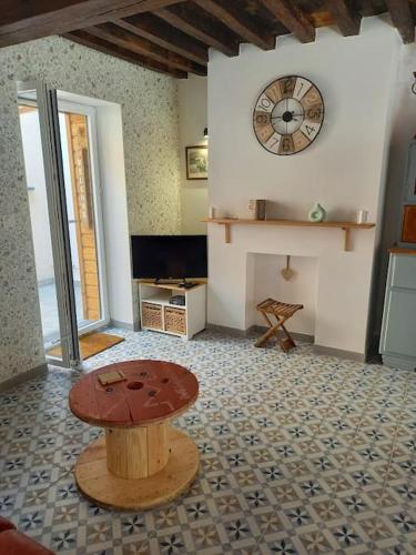 a room with a table and a clock on the wall at La Maisonnette Cambrésienne in Cambrai
