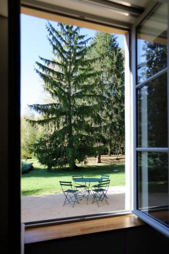 Elle offre une vue sur une table de pique-nique et un arbre. dans l'établissement L'atelier casse-noisettes-gitesdanslain, à Pont-dʼAin