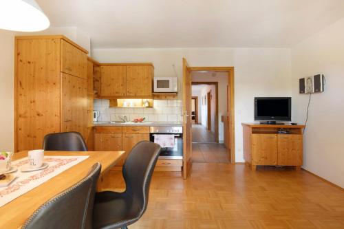 a kitchen with a table and chairs and a television at Ferienhof Schütz in Eschlkam