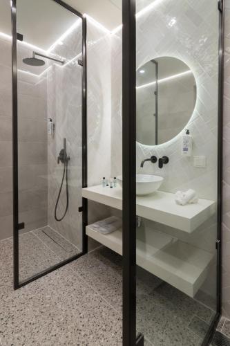 a bathroom with a sink and a shower with a mirror at Socrates Fully Equipped Apartments with Unique Design in Athens