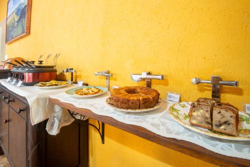 a table with three plates of bread and cakes on it at Pouso da Trilha Hospedagem in Lençóis
