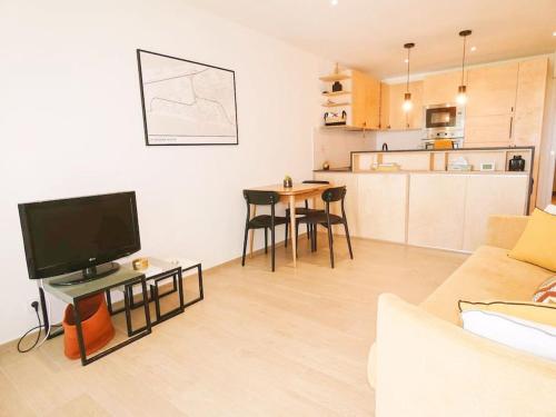 un salon avec un canapé et une table avec une télévision dans l'établissement Appartement en première ligne La Grande Motte Climatisé, à La Grande Motte