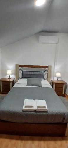 a bedroom with a large bed with two night stands at Ferradosa GuestHouse in São João da Pesqueira